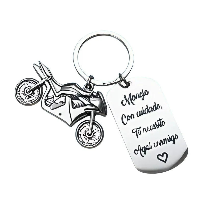 Close-up of a metal motorcycle-themed inspirational keychain next to a red flannel storage bag