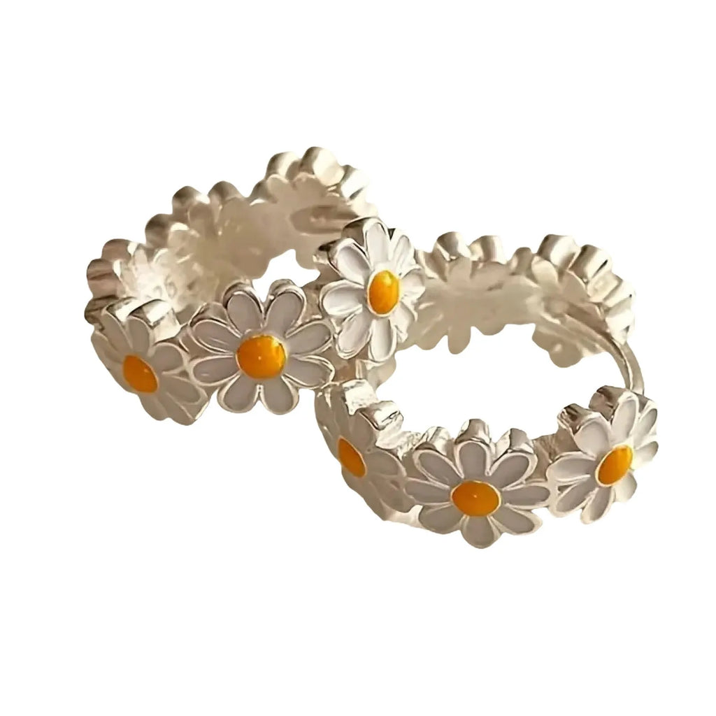 Pair of white daisy flower-shaped ring earrings with a gem inlay detail.