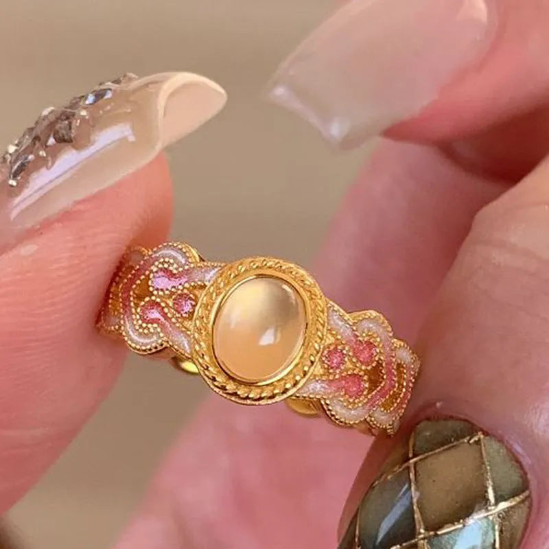 Geometric open mouth ring with pink crystal enamel on a gold-plated copper band.