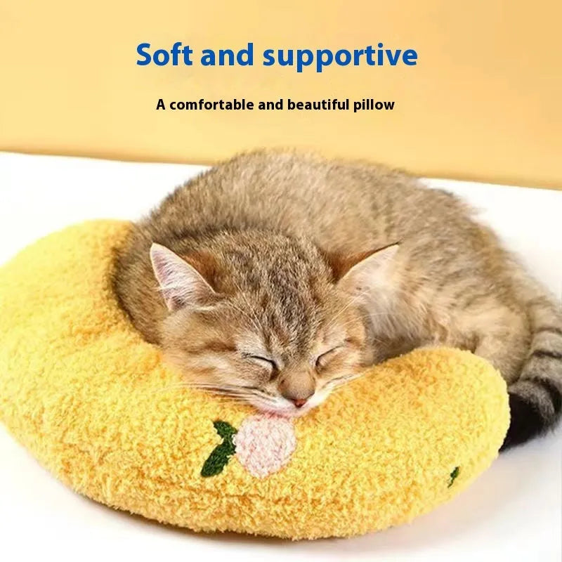 Blue U-shaped cat neck pillow in moon style next to a yellow question mark shaped pet bed.