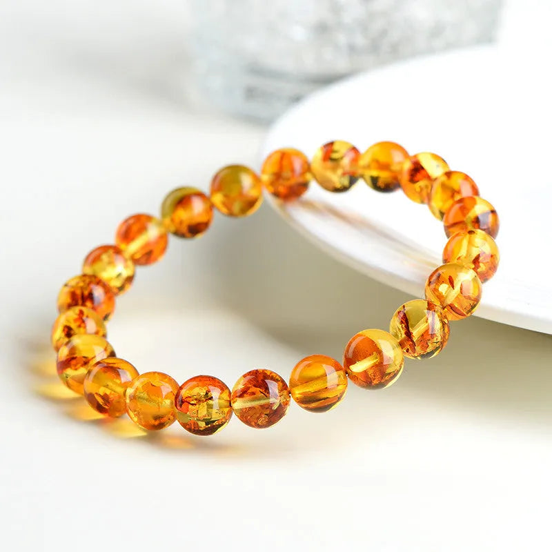 Natural yellow piebald amber bracelet with geometric beads on a white background.