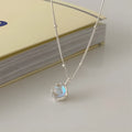 Women's silver geometric pendant necklace with adjustable curb chain on grey background