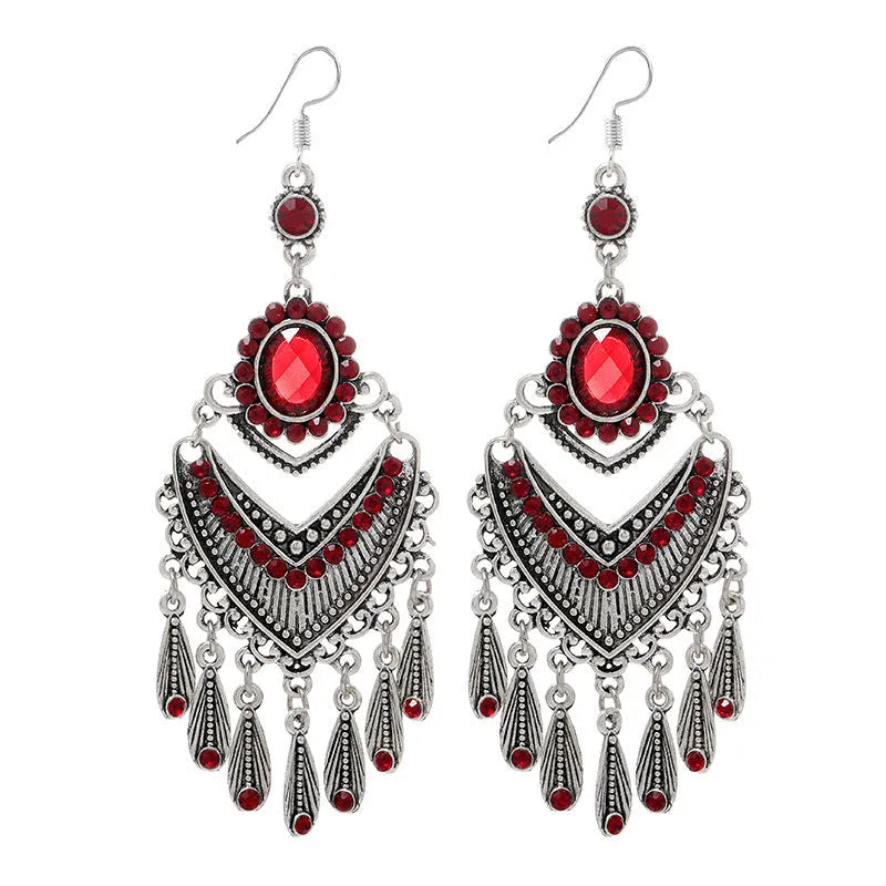 Close-up of long purple drop earrings with crystal fringe detail on an alloy setting.
