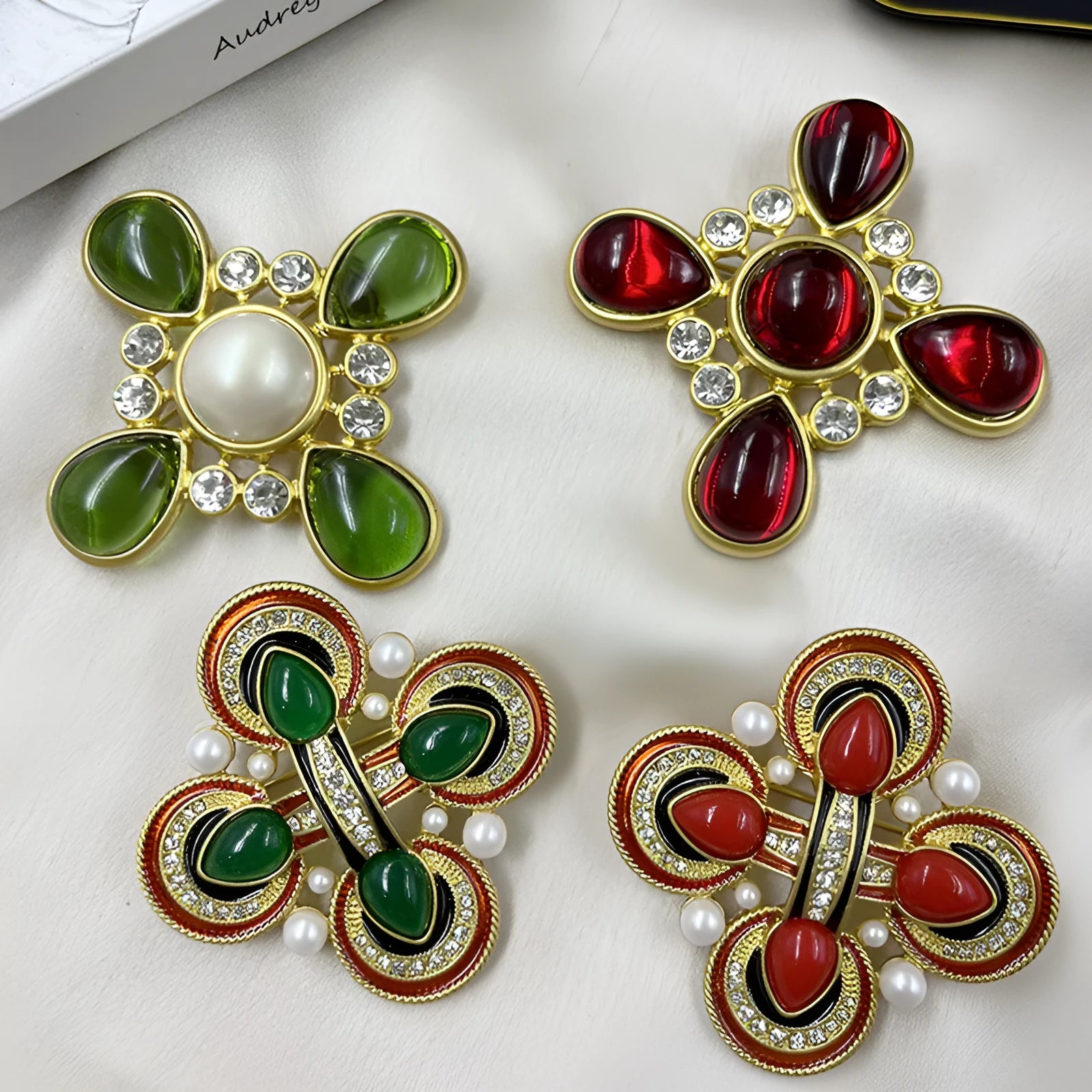 Vintage zinc alloy baroque cross brooch with crystal details on a dark fabric background.