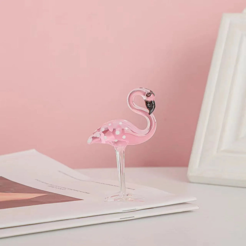 Clear crystal flamingo decorative sculpture with pink dots on a table.