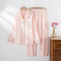 Women's pink cotton long sleeve pajama top and trousers set on hanger.