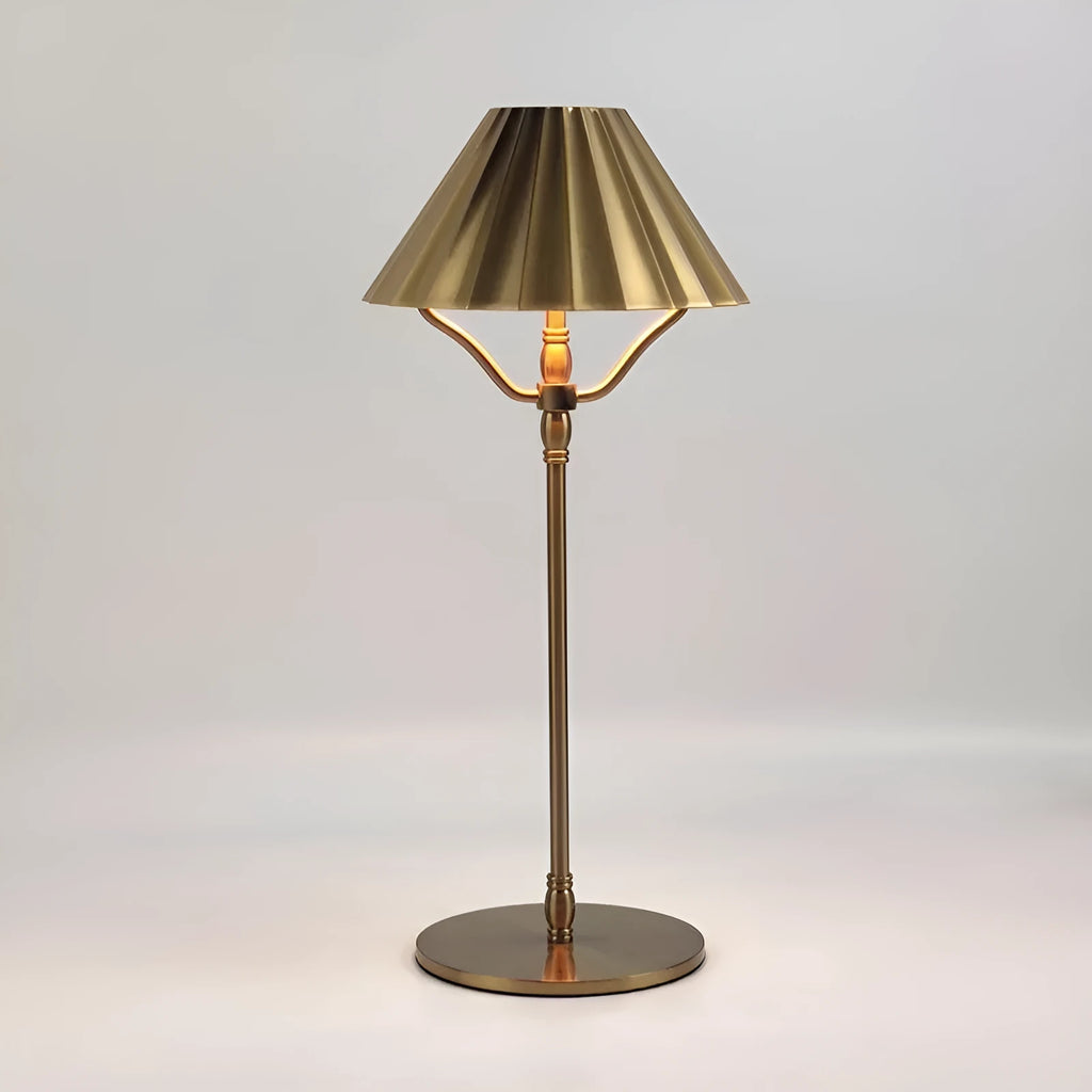 Gold alloy desk lamp with a cylindrical shade, shown lit with warm white light on a wooden desk.