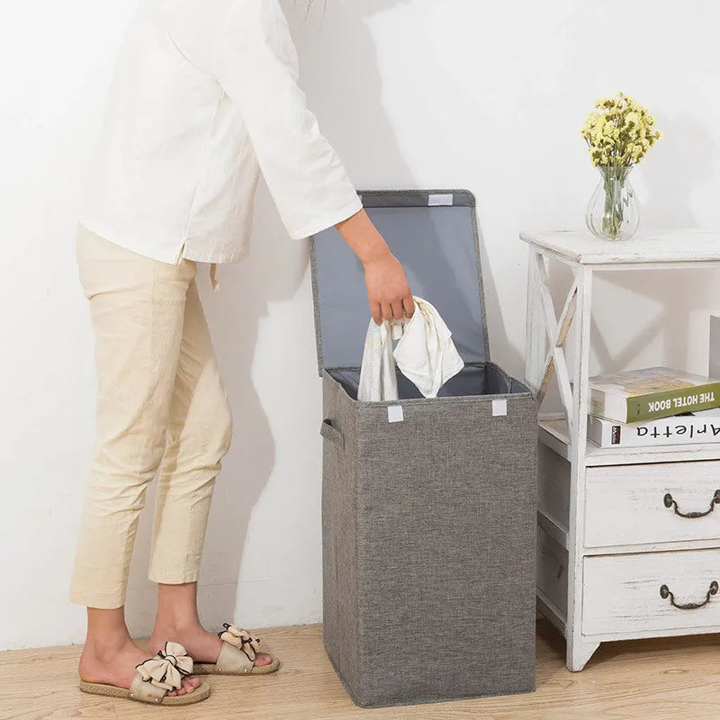 Grey foldable cotton linen storage basket shown next to a folded towel and a book.