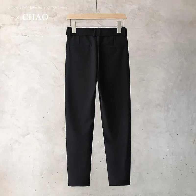 Boy wearing slim straight grey wool trousers with a tapered fit and straight leg opening.