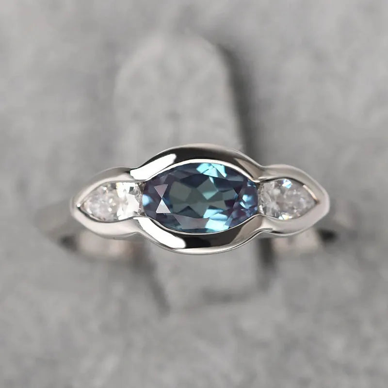 Geometric ellipse-shaped women's ring with inlaid zircon stones in a white gold finish.