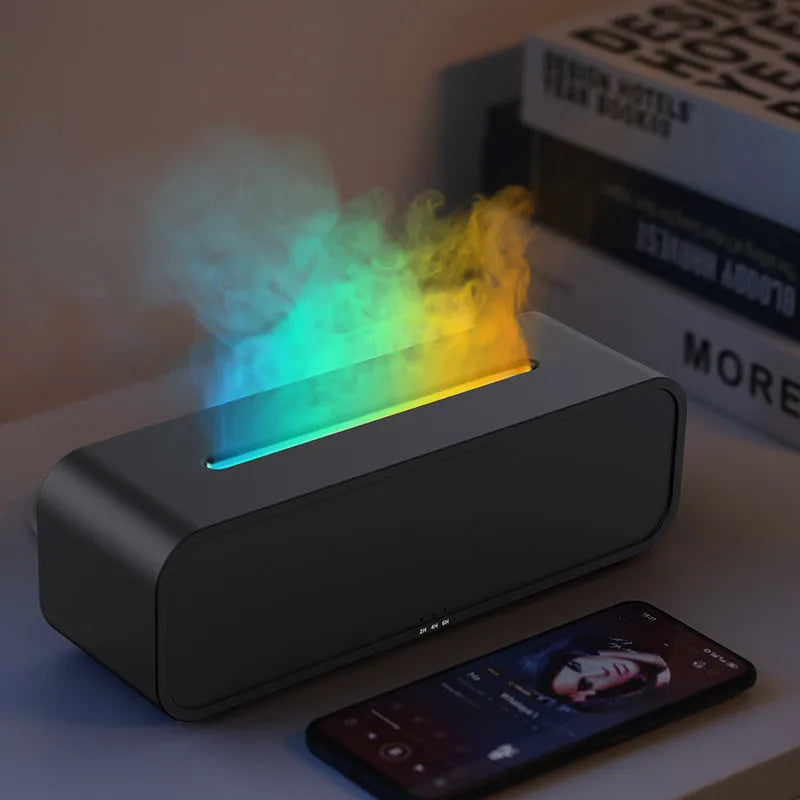 Black and white aroma diffuser with flame animation and coloured LED lights on a wooden table.