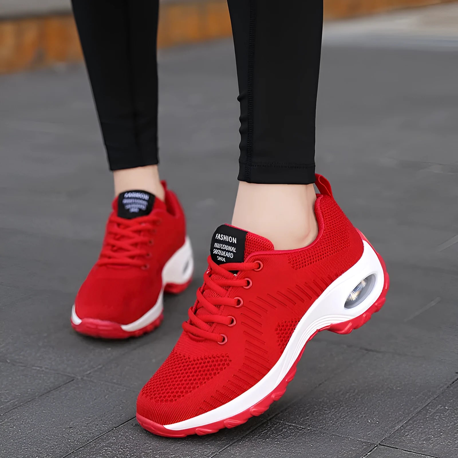 Women's red and black mesh front lace-up low top sneakers with round toe and flat mid-heel on a white background.