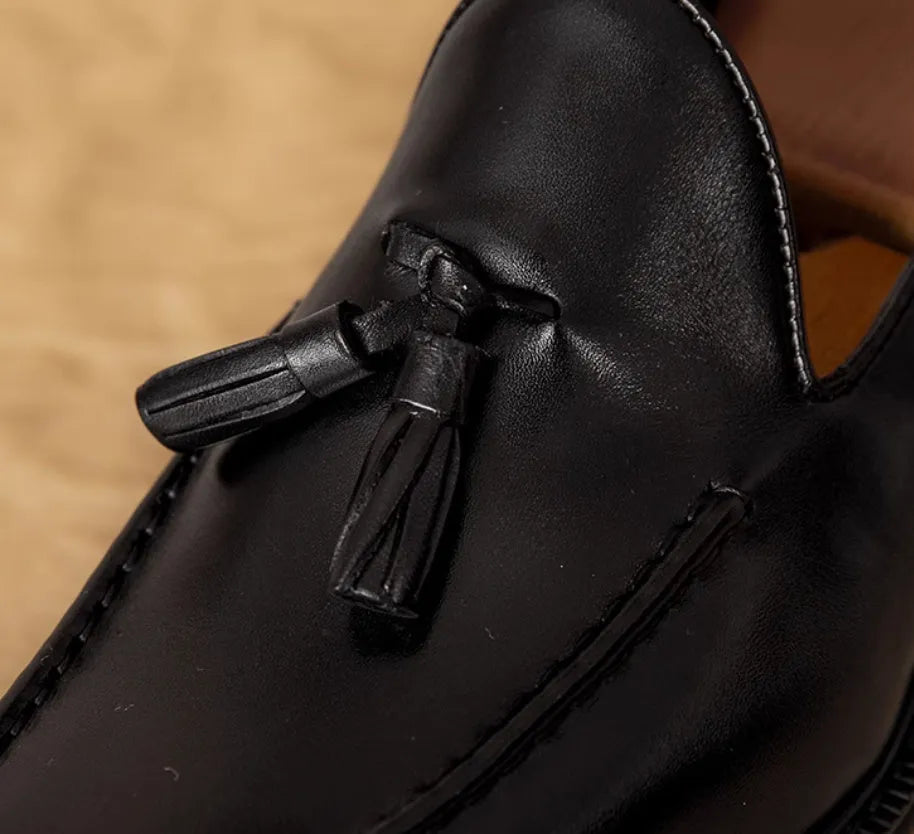 Men's black genuine leather slip-on loafers with fringed detailing on a white background