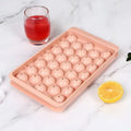 Blue silicone ice cube tray with lid showing 33 round moulds for homemade ice making