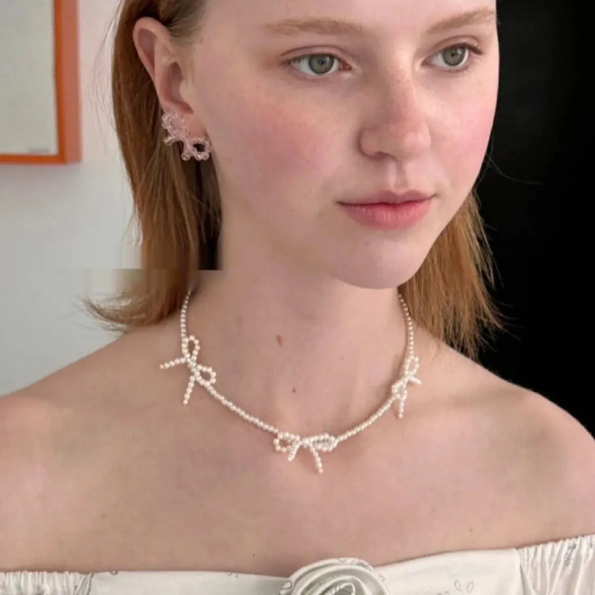White imitation pearl necklace for women with an adjustable chain and a geometric sweet bow charm.