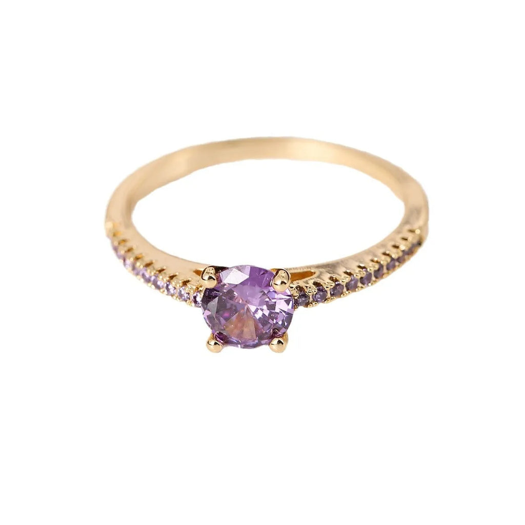 A geometric hexagonal zircon ring in copper, shown in a gold rose red electroplated finish on a size 7 finger.