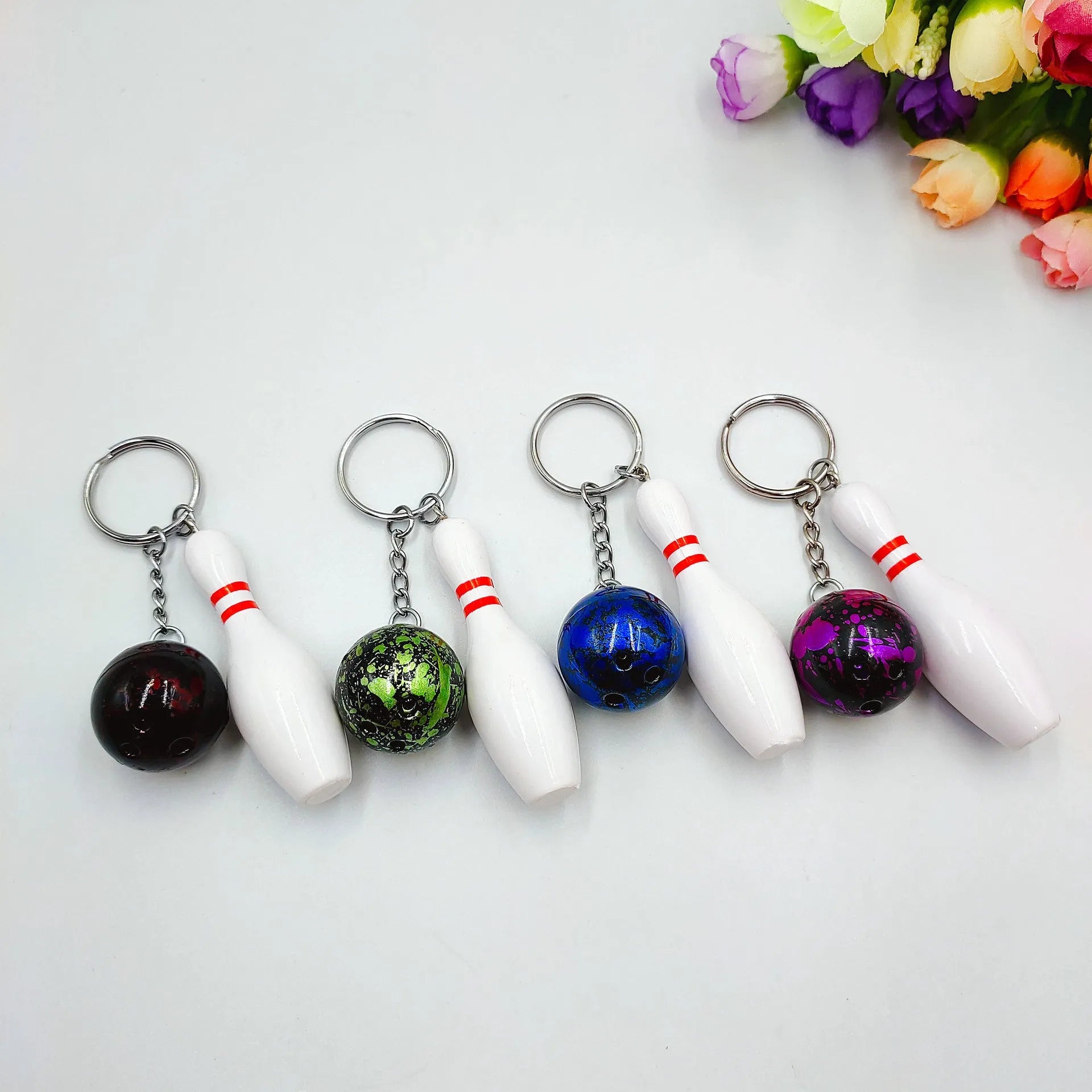 Mini bowling simulation keychain pendant in PVC metal showing four colour options