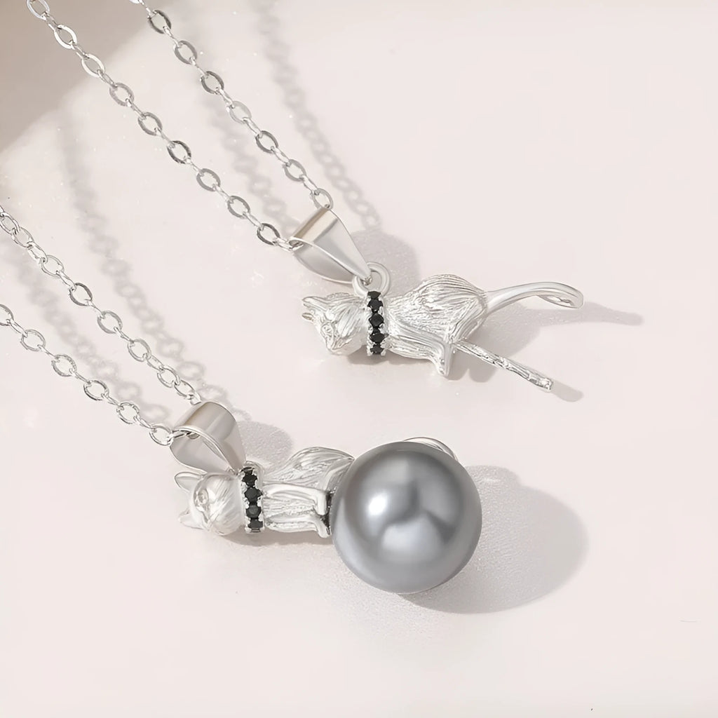 Close-up of a sterling silver cat pendant on a clavicle necklace chain.