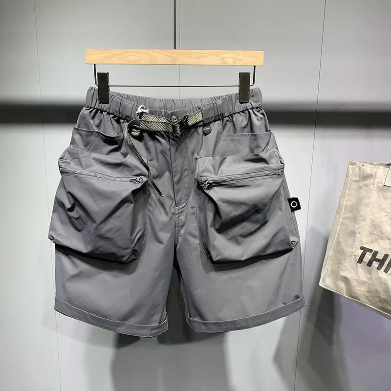 Men's loose fit black work shorts with pockets, shown on a model
