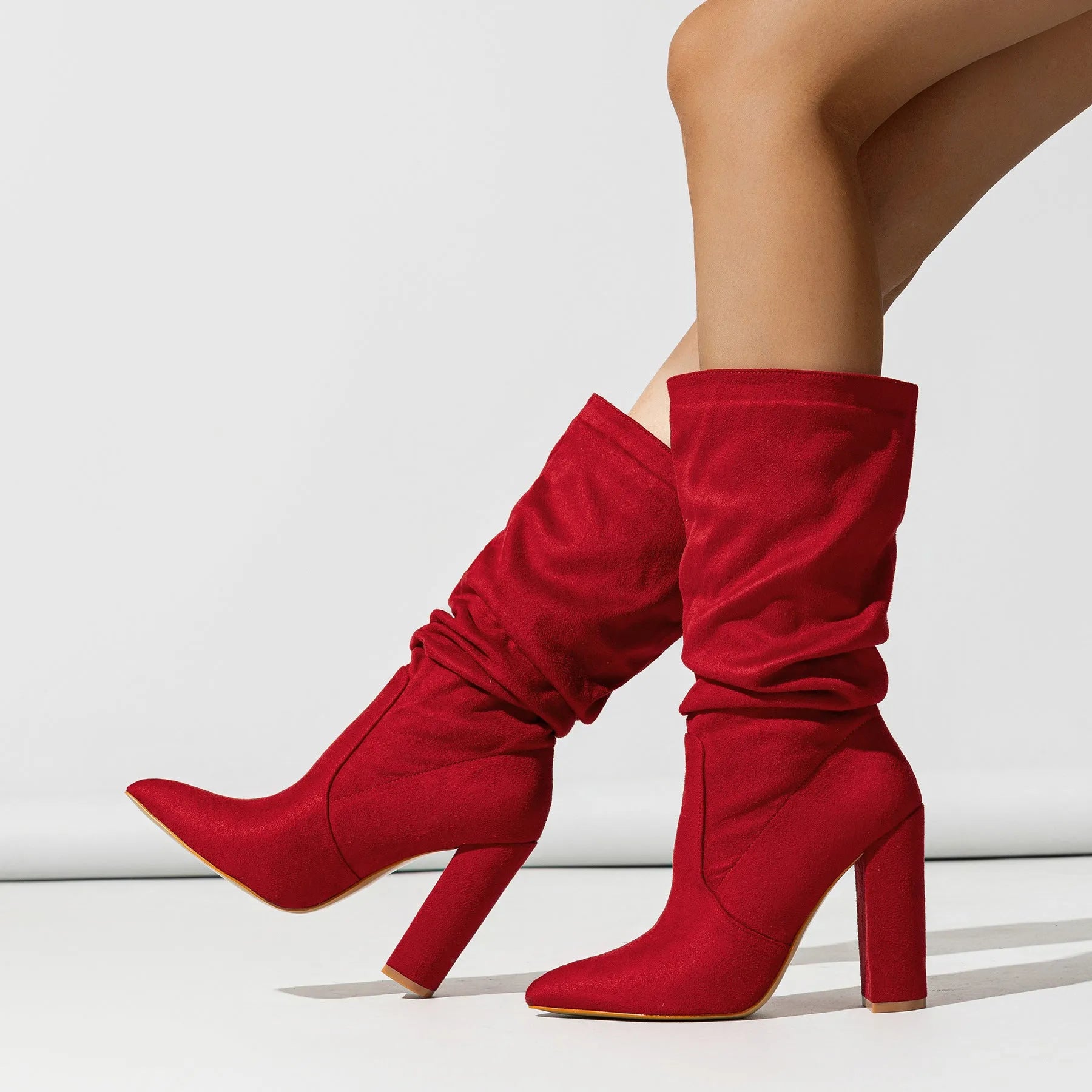 Black suede women's boots with a pointed toe and a thick chunky high heel, mid-calf length.