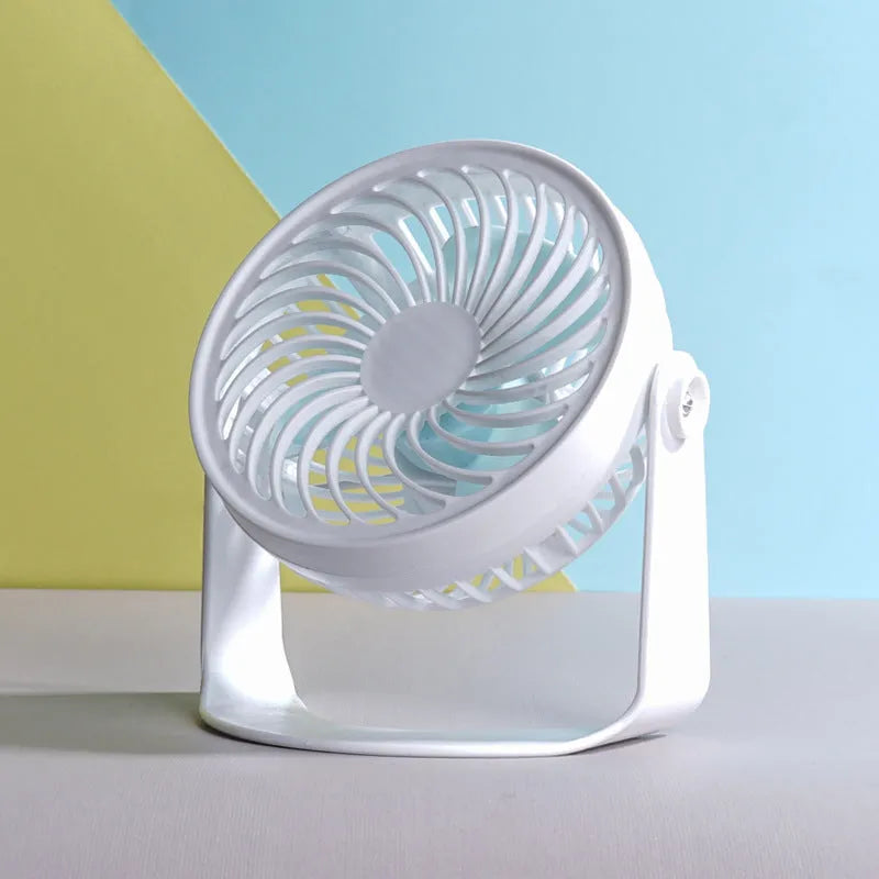 Small white USB desktop fan with clip attached to a desk edge, showing three blades.