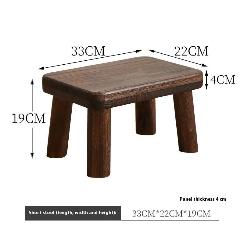 Solid wood household changing stool with a distressed finish for shoes in a living room.
