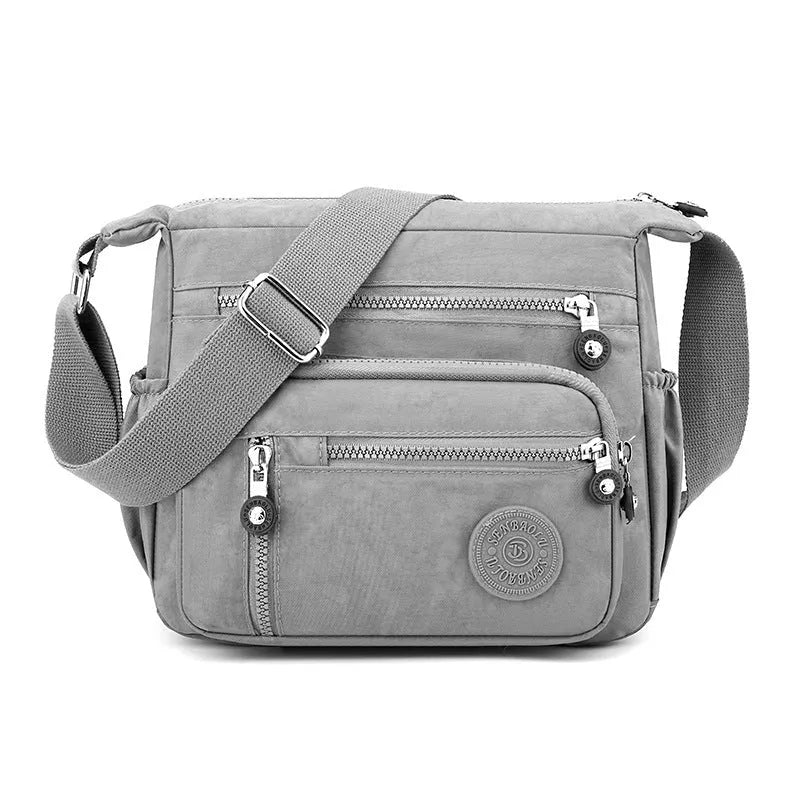 Soft nylon messenger bag in grey, shown as a square vertical model with a single shoulder strap.