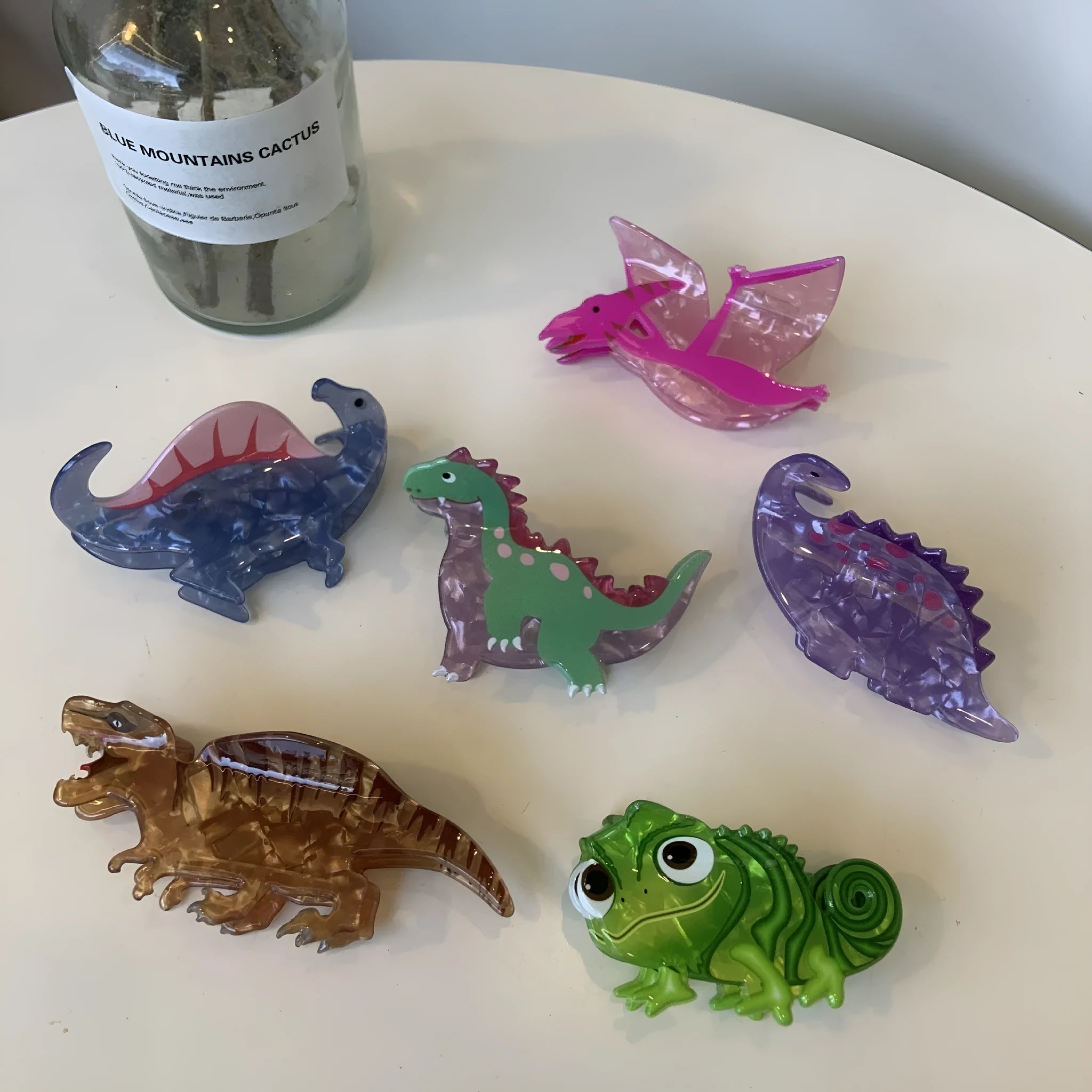 Dinosaur acrylic jaw hair clip showing grip mechanism and detailed dinosaur design in available colour options