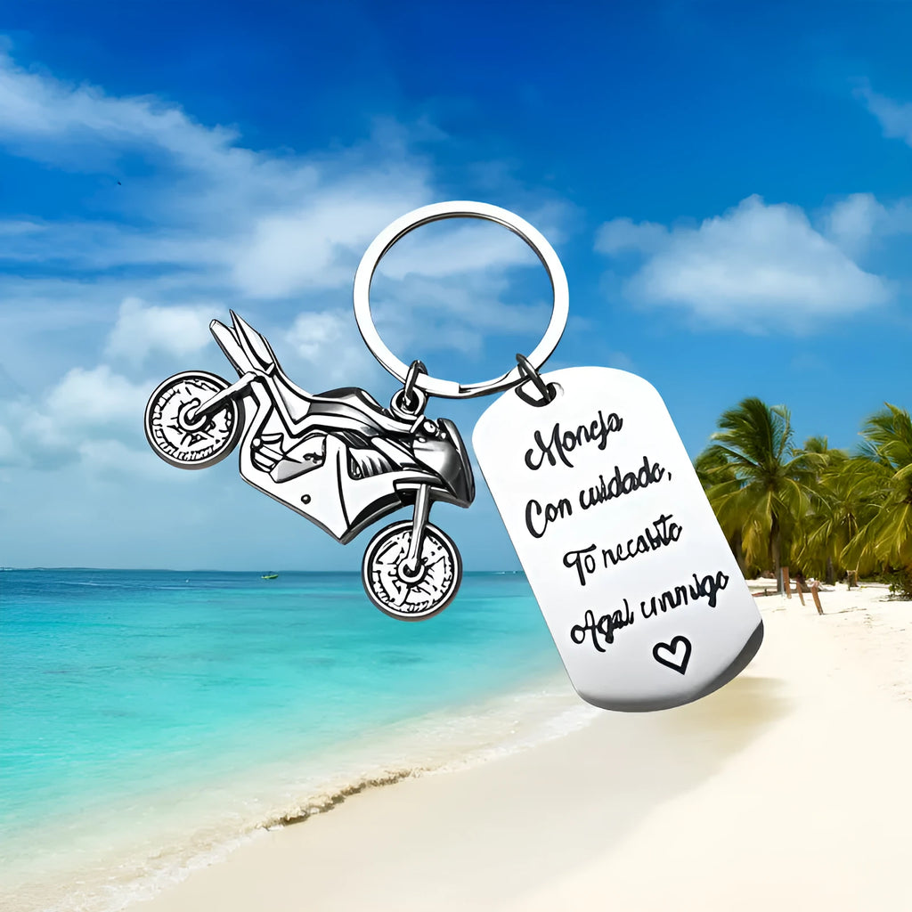 Close-up of a metal motorcycle-themed inspirational keychain next to a red flannel storage bag