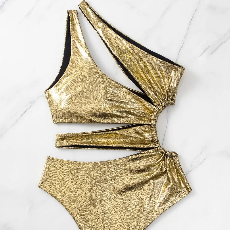 Women's gold backless one-piece swimsuit on a white background