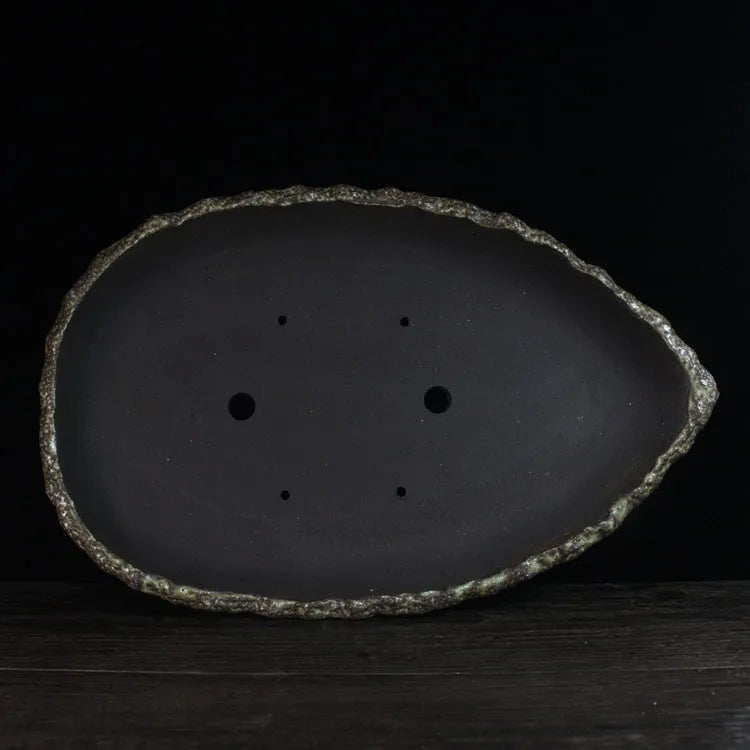 Handmade purple clay flower pot showing unique shape and texture with floor-standing design