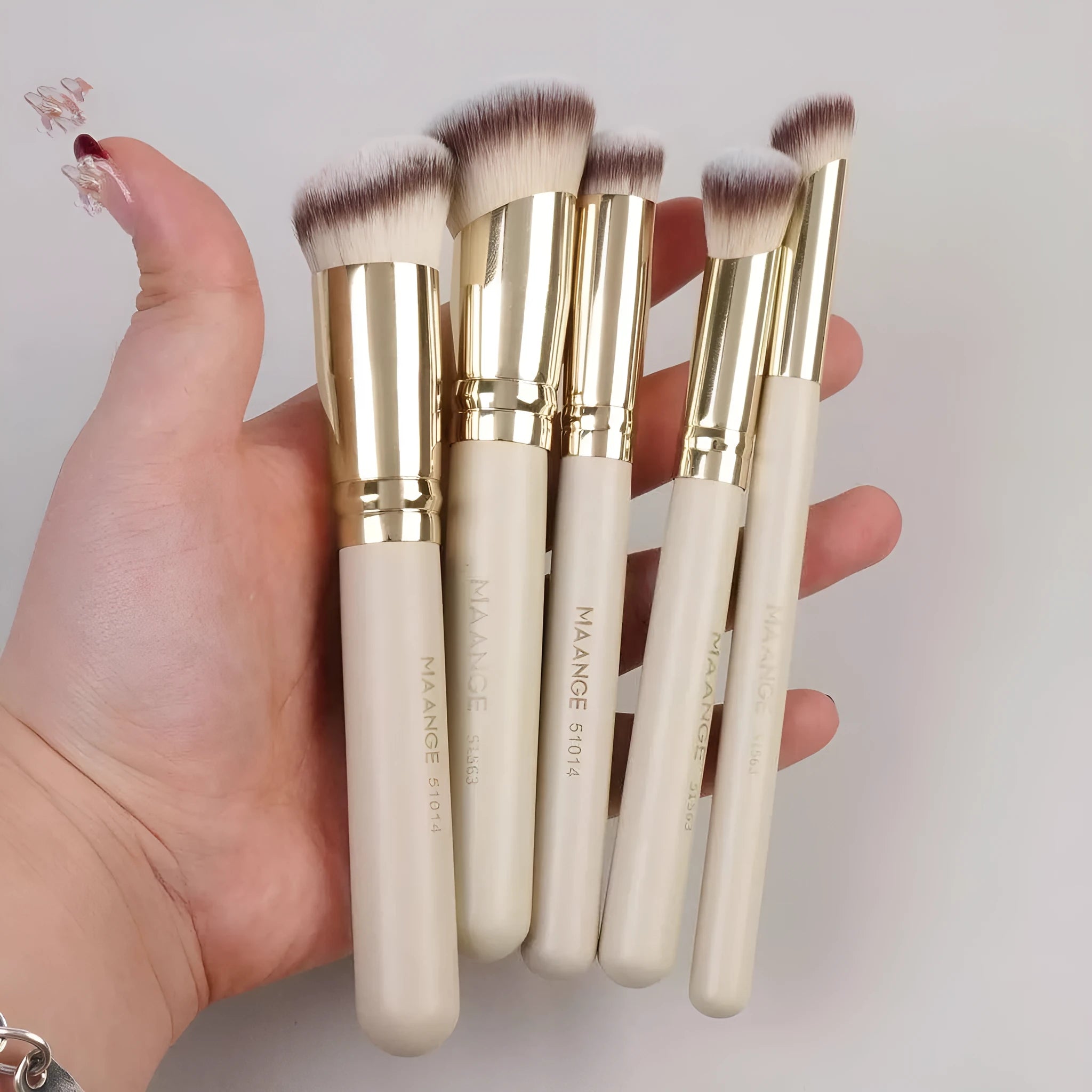 MAANGE apricot coloured five-piece angled blush and kabuki makeup brush set.