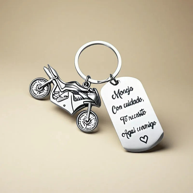 Close-up of a metal motorcycle-themed inspirational keychain next to a red flannel storage bag