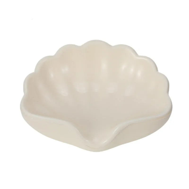 White or pink plastic shell-shaped soap dish for bathroom countertops.
