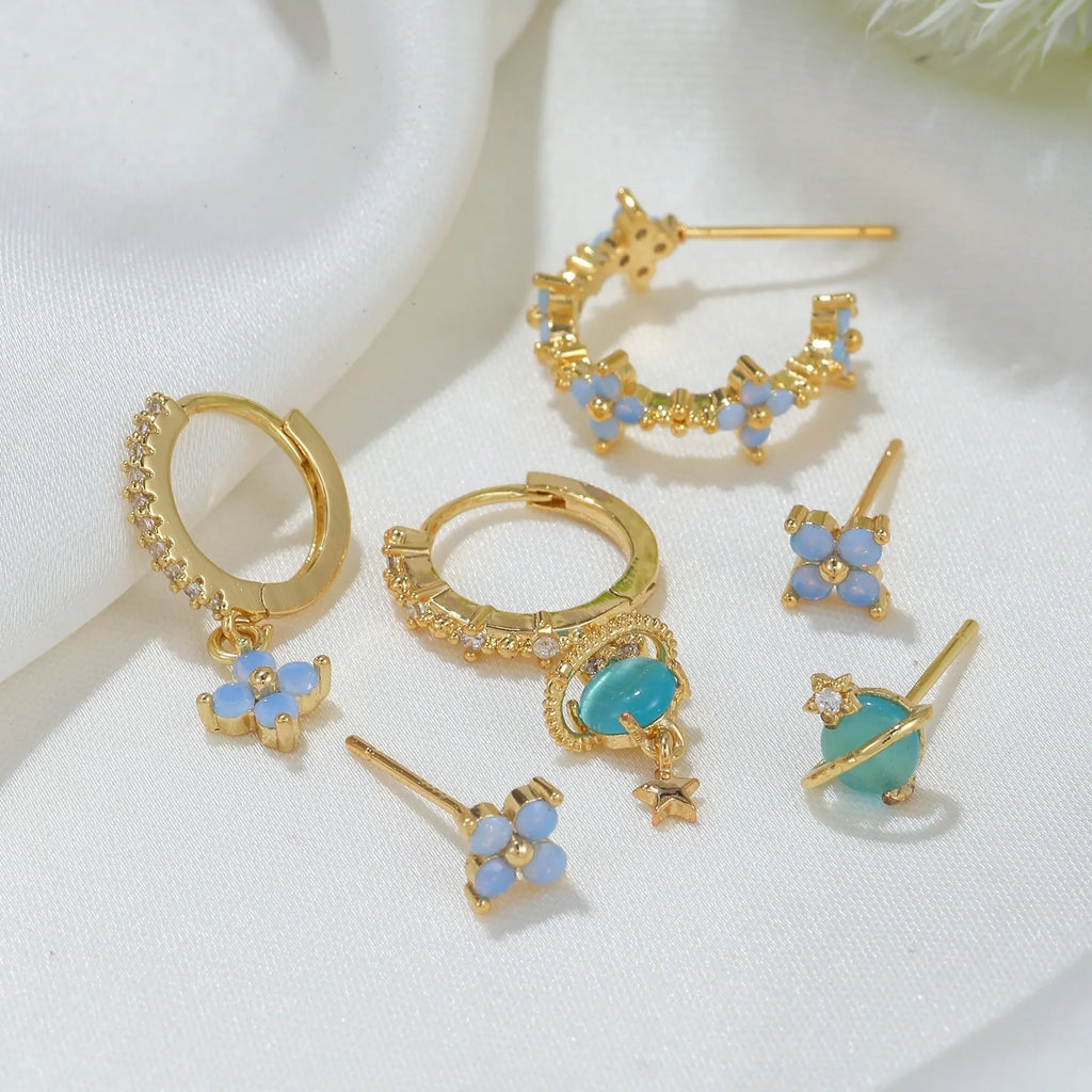 Gold and silver floral stud earrings with blue protein flower nail and zircon mosaic detail.
