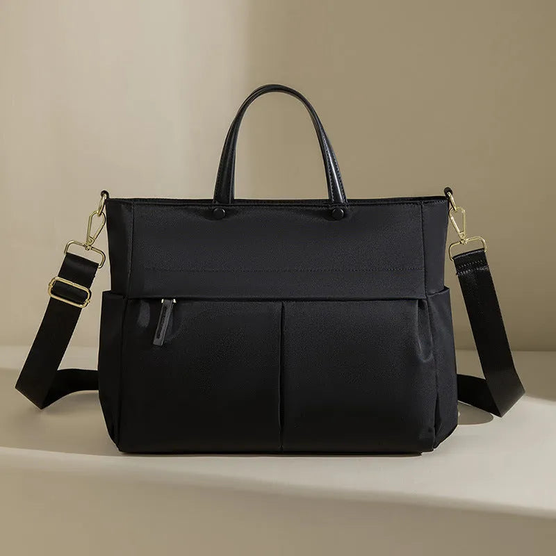Women's Oxford cloth briefcase with shoulder strap showing open pocket organisation and contrast stitching details