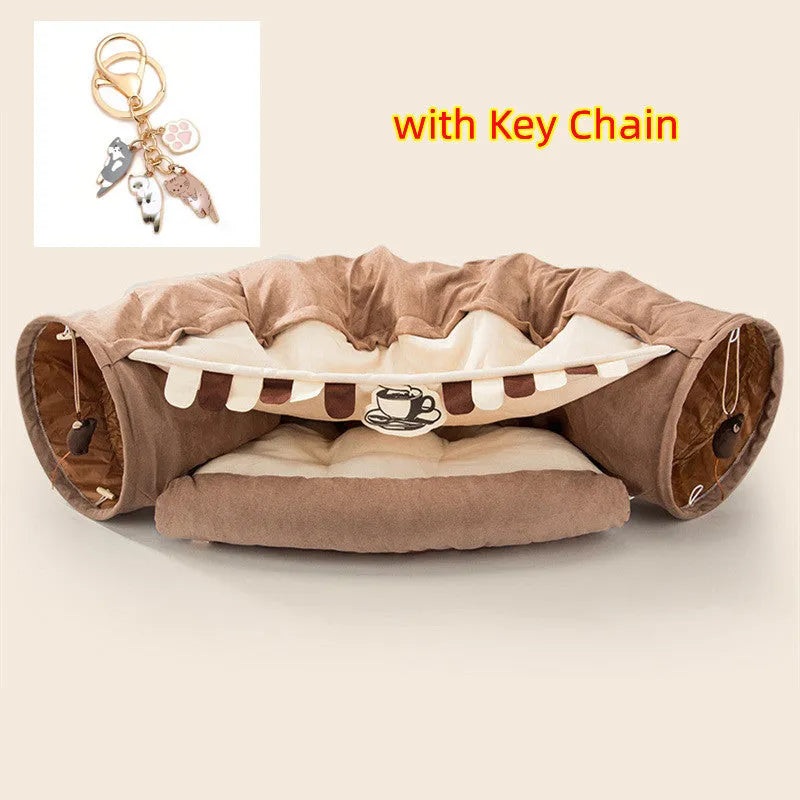 Collapsible cloth cat tunnel folded flat next to a cat, showing Coffee colour option.