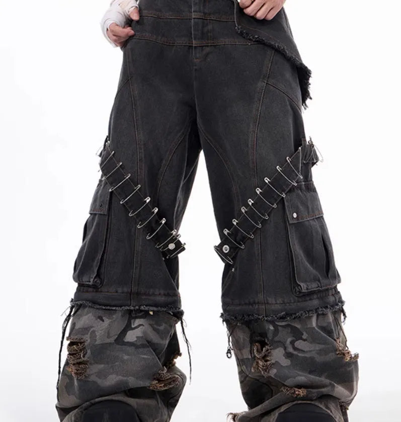 Grey men's jeans with camouflage pattern splicing and silver pin and black ribbon detailing on the legs.