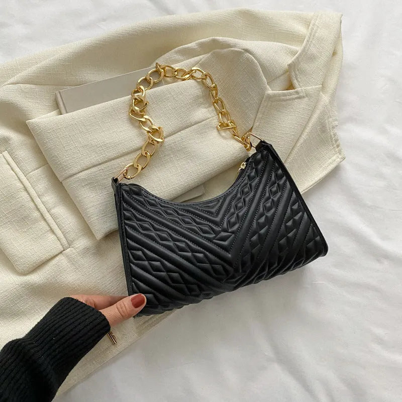 Brown pleated chain baguette women's shoulder bag with adjustable strap on a mannequin.