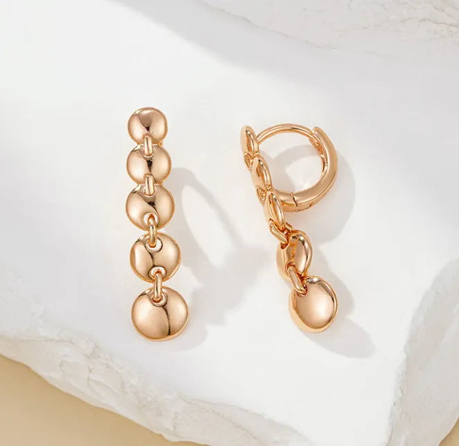 Gold tone retro earrings with a round circle shape and surface weave design, hanging as a dangle.