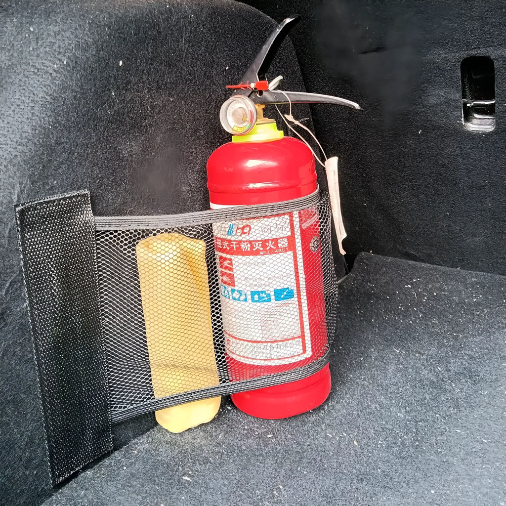 Black elastic polyester storage net stretched in a car boot, holding a water bottle and cloth.