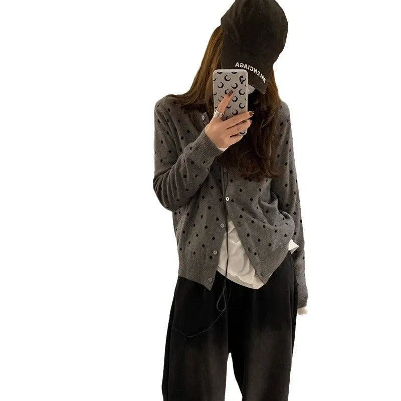 Women's grey dot knitted cardigan with long sleeves and crocheted flower detail.