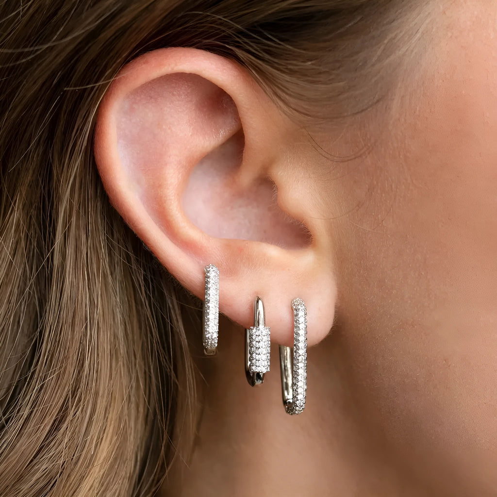Geometric ear clips set with micro inlaid zircon detailing on copper, showing ellipse and quadrilateral shapes in gold and white finishes