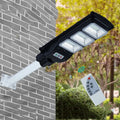 Integrated solar street light with 60W LED panel and remote control for outdoor pathway illumination.