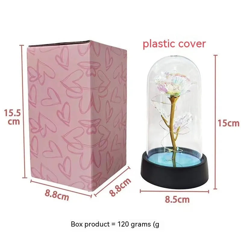 Small decorative night lamp with a glass cover and plastic flowers on a black base.