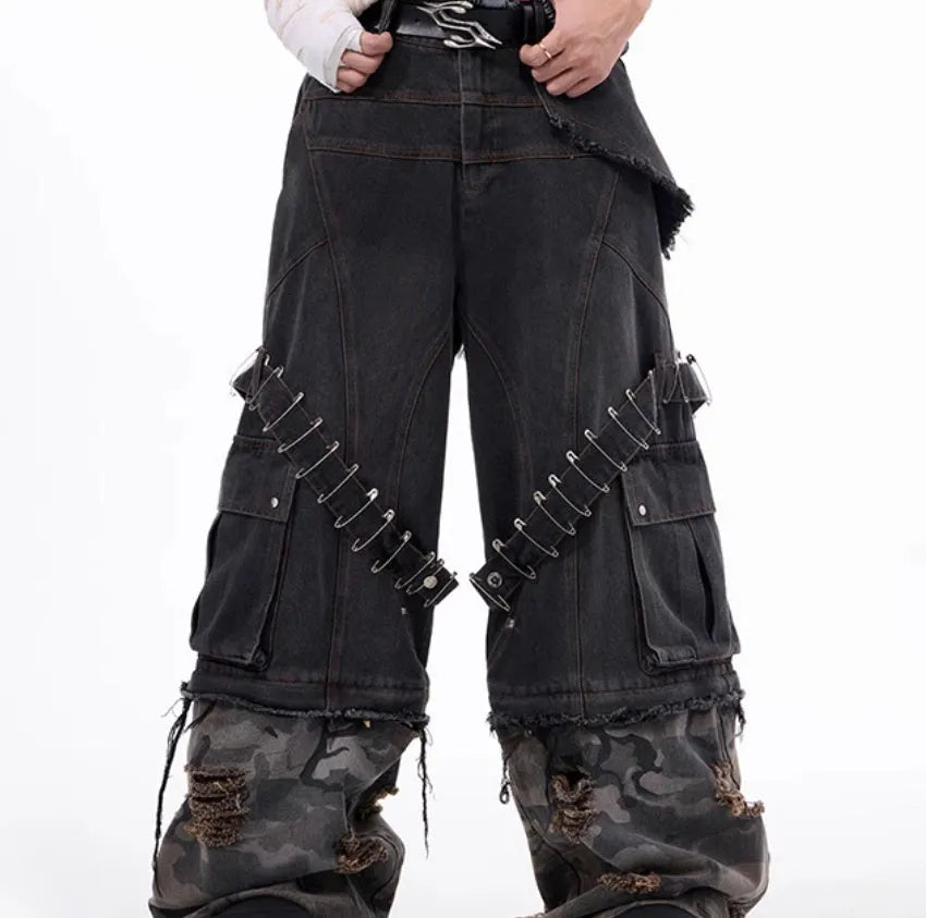 Grey men's jeans with camouflage pattern splicing and silver pin and black ribbon detailing on the legs.