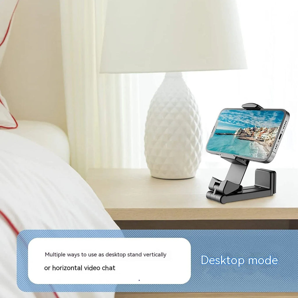 Black foldable rotating phone holder holding a mobile phone on a desk.