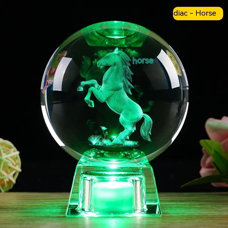White luminous crystal ball ornament with Chinese zodiac animal figure on electronic base.