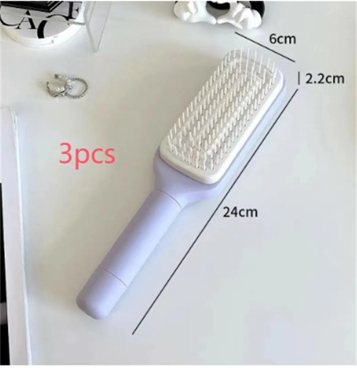 Roland purple self-cleaning hair brush with rotating handle and anti-static massage bristles.