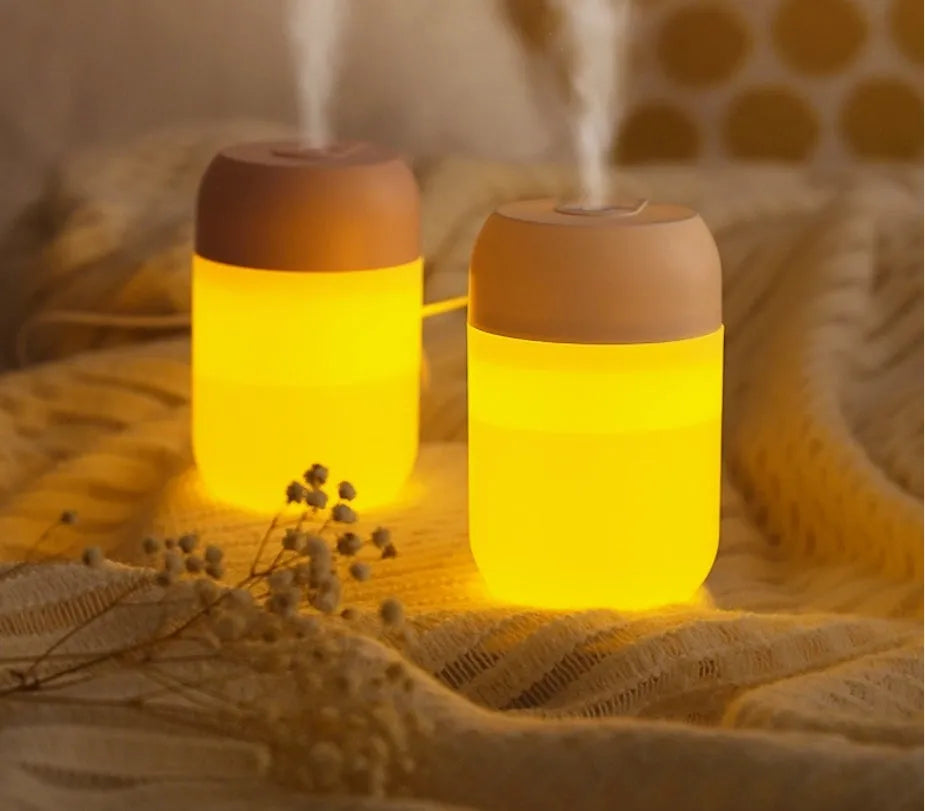 White cylindrical mini USB humidifier with aromatherapy function on wooden desk